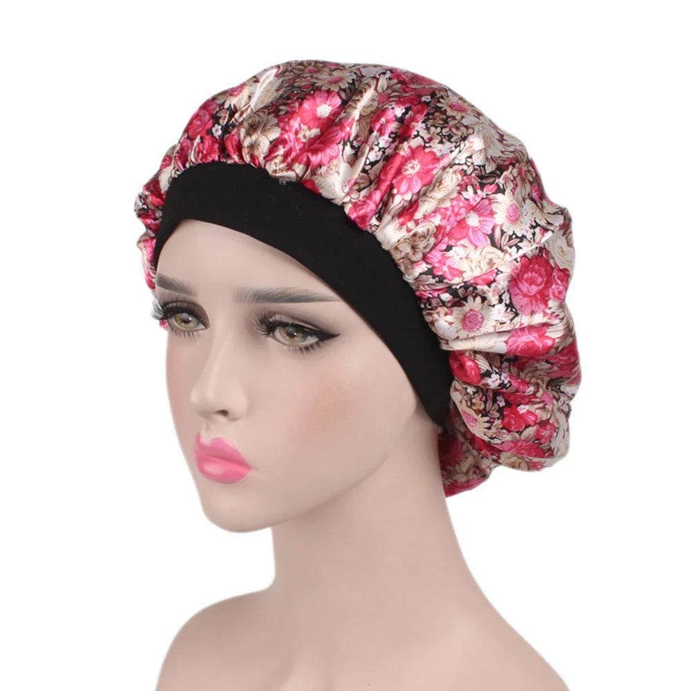 A woman wearing a floral patterned satin hair bonnet with a black elastic band.