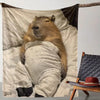 A cartoon capybara is lying down on a light-colored flannel blanket, draped over a wooden frame.