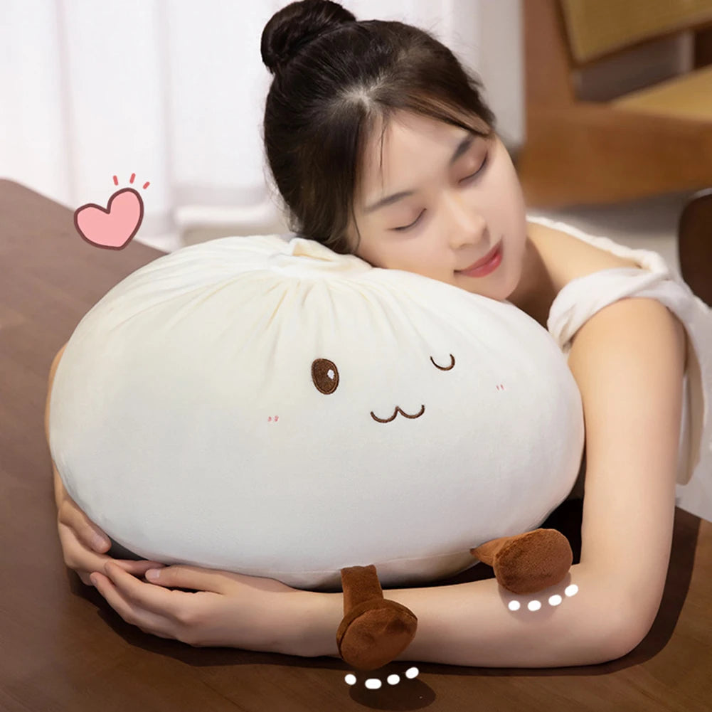 Une femme fait un câlin à un coussin en peluche mignon en forme de dumpling blanc et rond.