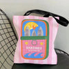 A pink striped canvas tote bag featuring a graphic print of sardines in olive oil.