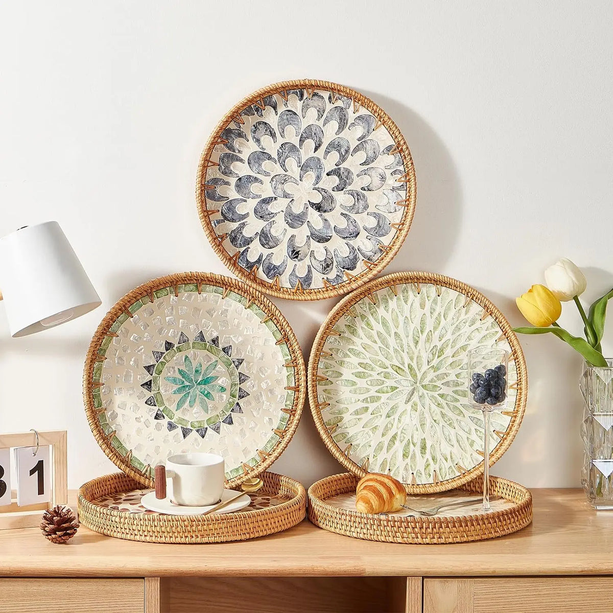 Handcrafted rattan serving tray with mother of pearl inlay featuring decorative plates and a small loaf of bread.