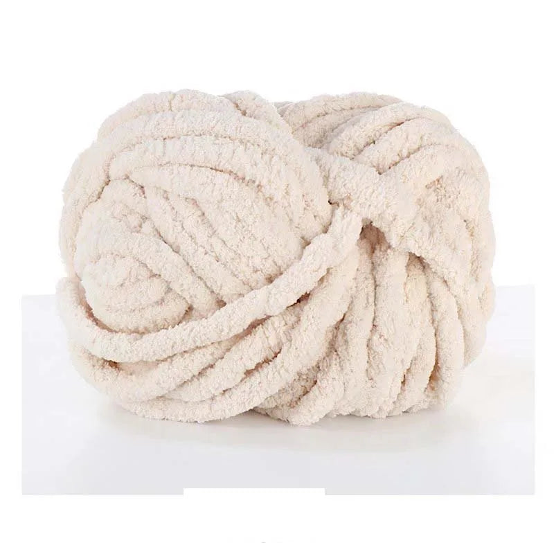 A ball of light beige chunky acrylic yarn used for knitting and crochet