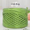 A spool of metallic green flat ribbon yarn for crochet and knitting.