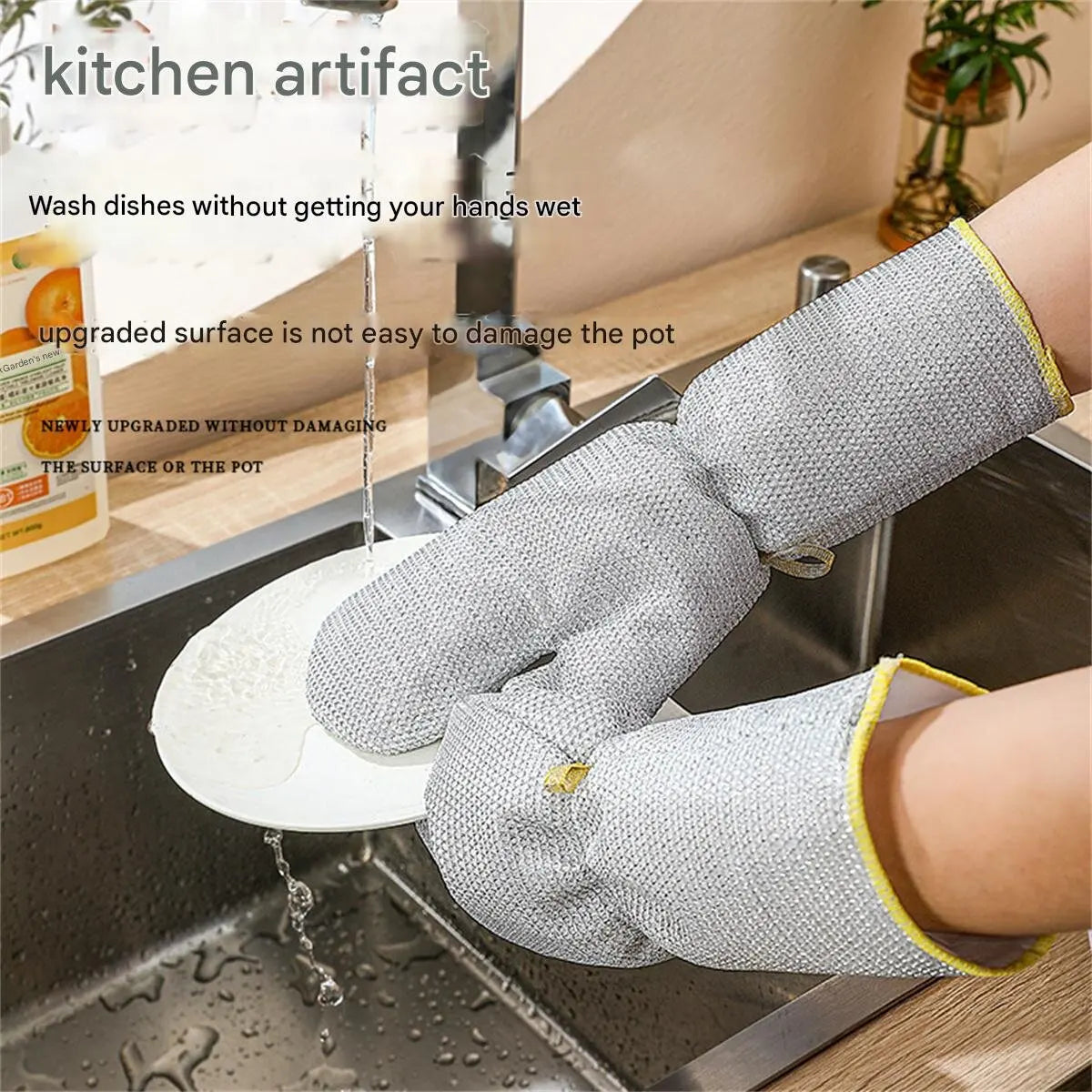 A hand wearing a gray steel-wire dishwashing glove is washing dishes in a stainless steel sink.