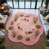 A round pink plush rug with a koi fish pattern is placed on a wooden floor.