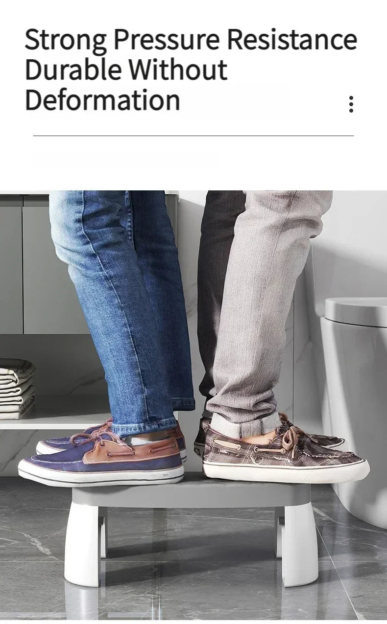 A pair of brown and gray leather shoes are placed on a modern white stool in front of a toilet.