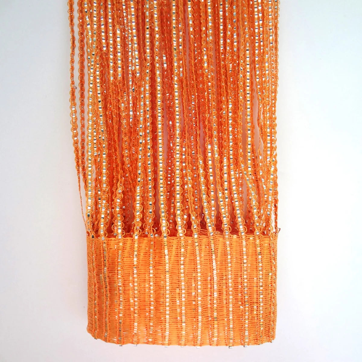 Orange boho tassel string curtain hanging vertically