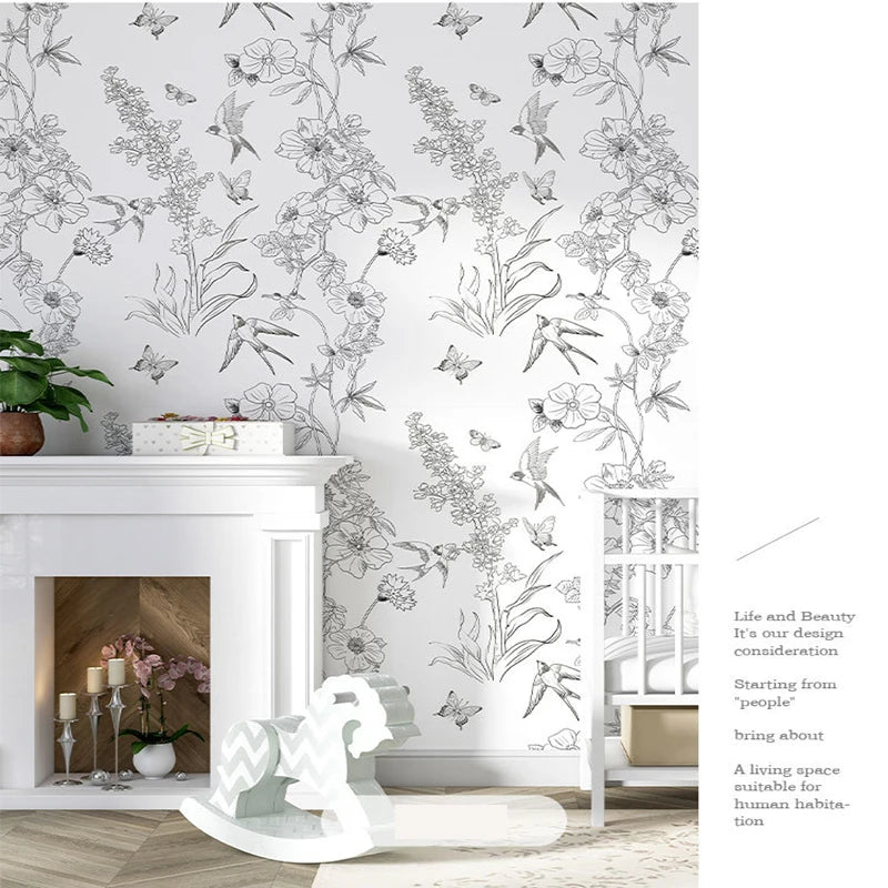 A white fireplace mantel decorated with a Boho Leaf Peel-and-Stick wallpaper featuring green and white floral designs on the 