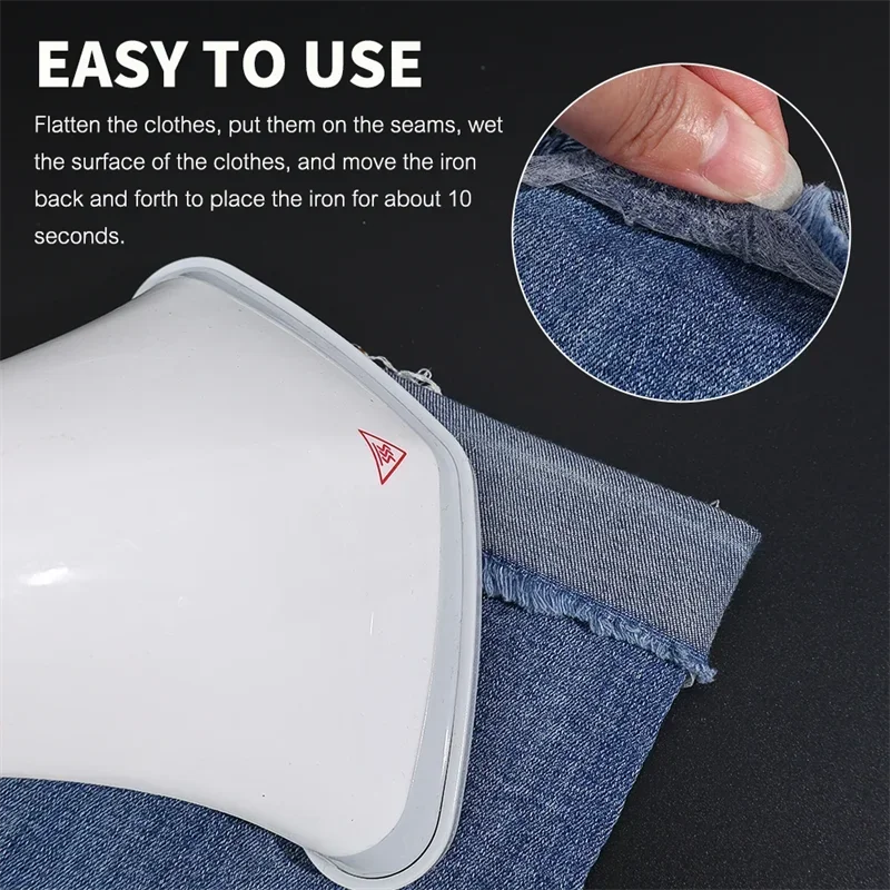 A close-up of a white iron-on adhesive tape being used to flatten and secure fabric on a denim garment.