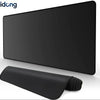A black extended anti-slip desk pad with stitched edges is shown on a white surface.
