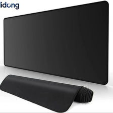 A black extended anti-slip desk pad with stitched edges is shown on a white surface.