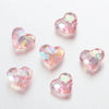 A collection of twenty pink and iridescent acrylic heart beads for jewelry making