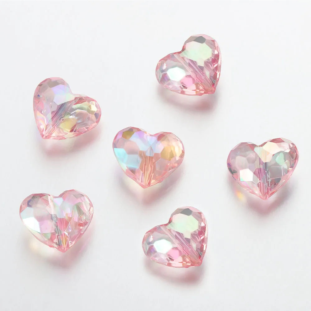A collection of twenty pink and iridescent acrylic heart beads for jewelry making