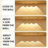 Three examples showing the placement of a rechargeable motion sensor LED cabinet light close to a wall.