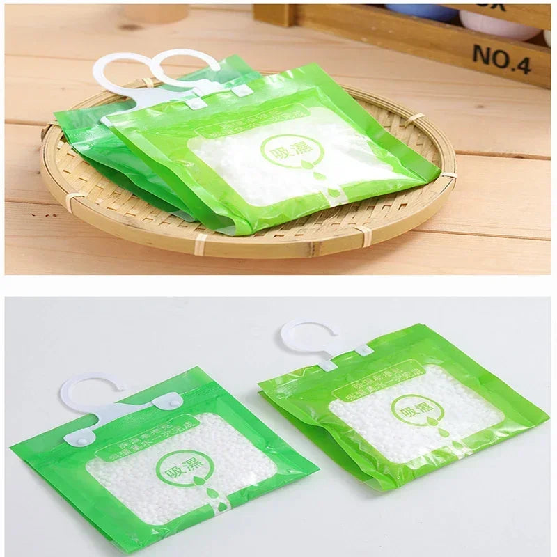 Two green hanging bags filled with moisture absorber material are displayed on a wooden tray.