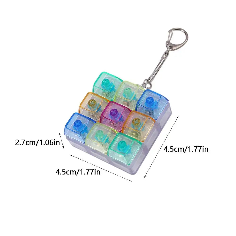 Llavero de teclado mecánico mini con teclas transparentes de varios colores y un anillo metálico adjunto.