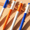 Four colored prank water gun pens displayed diagonally on a light background.