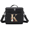 Black insulated canvas lunch bag featuring a gold letter K design and adjustable straps.
