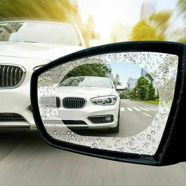 Pegatinas antiempañamiento aplicadas al espejo retrovisor de un coche, mostrando un BMW blanco.
