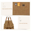 A brown canvas apron with a large front pocket and cross anti slip straps is shown alongside its packaging.