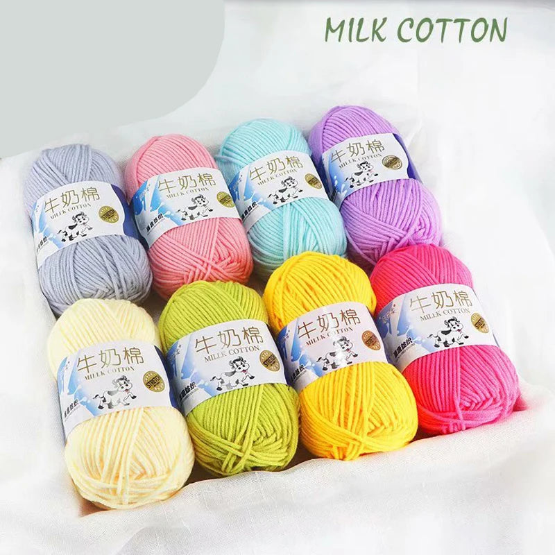 A collection of brightly colored milk cotton yarn skeins in various shades including pink, purple, blue, and yellow.