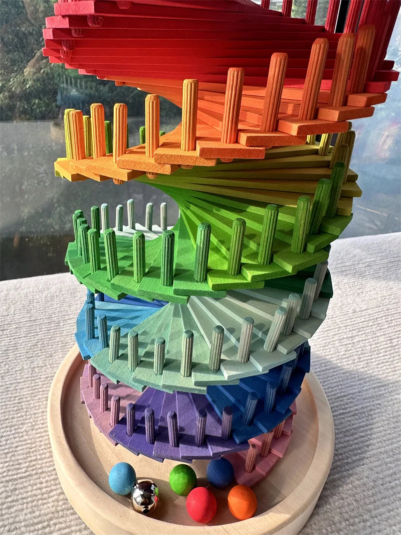 Buntes Holz-Marbly-Rennsystem mit gestaffelten Blütenblättern in Regenbogenfarben und kleinen bunten Murmeln als Basis
