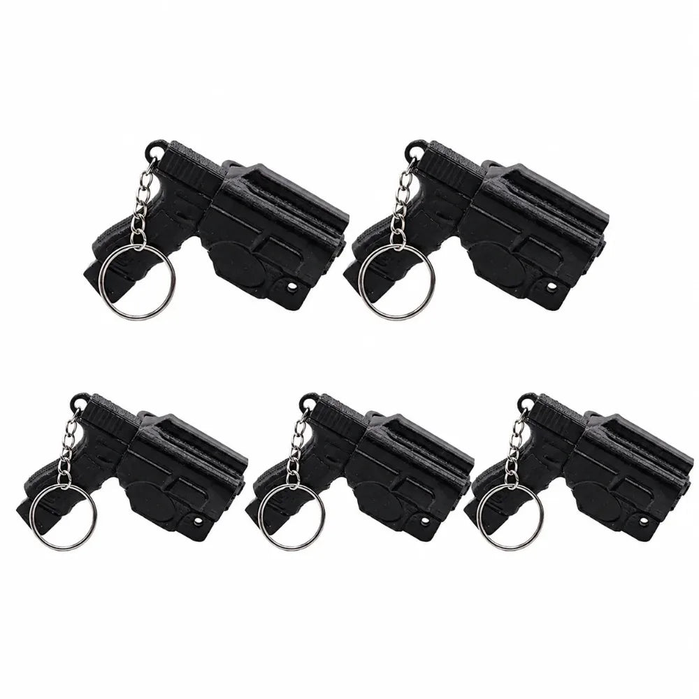 A set of black mini pistol-shaped keychain accessories with silver rings.