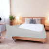 A light gray stretch-fit box spring cover with an elastic edge placed on a wooden bed frame.