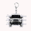 A silver metal key ring featuring a detailed model of an off-road truck.