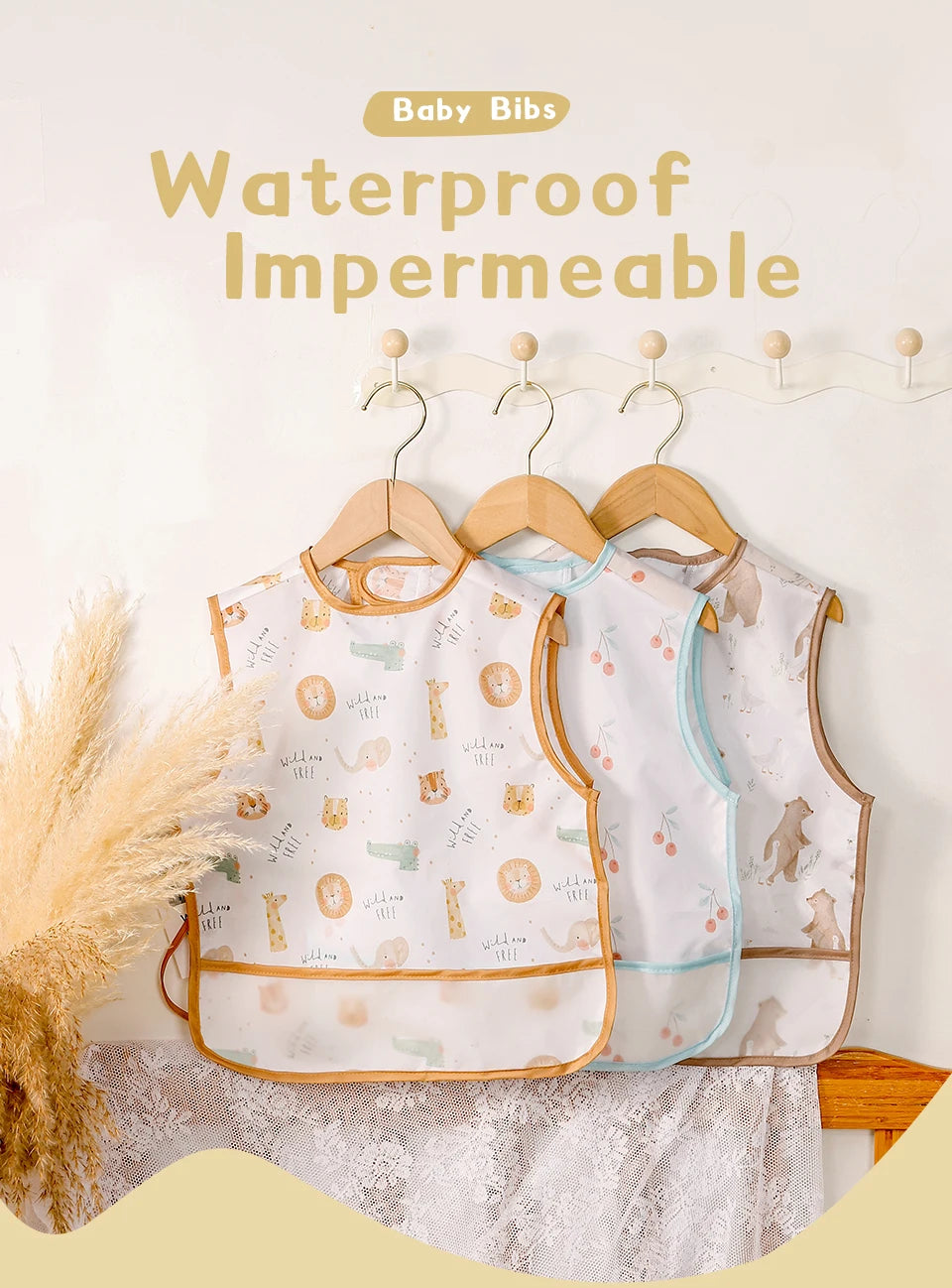 A set of waterproof baby bibs in white and light blue featuring cute animal patterns displayed on a wooden hanger.