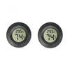 A close-up view of a black mini digital hygrometer thermometer displaying 29.5°C and 74% humidity.
