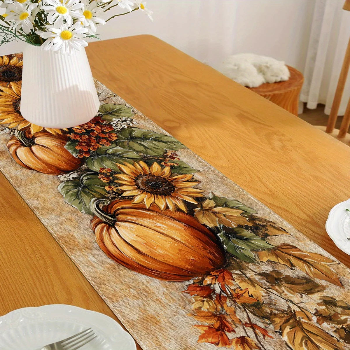 Autumn harvest table runner featuring pumpkins, sunflowers, and foliage on a wooden table.