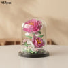 A clear glass display featuring a miniature pink and white rose bouquet made of building blocks.