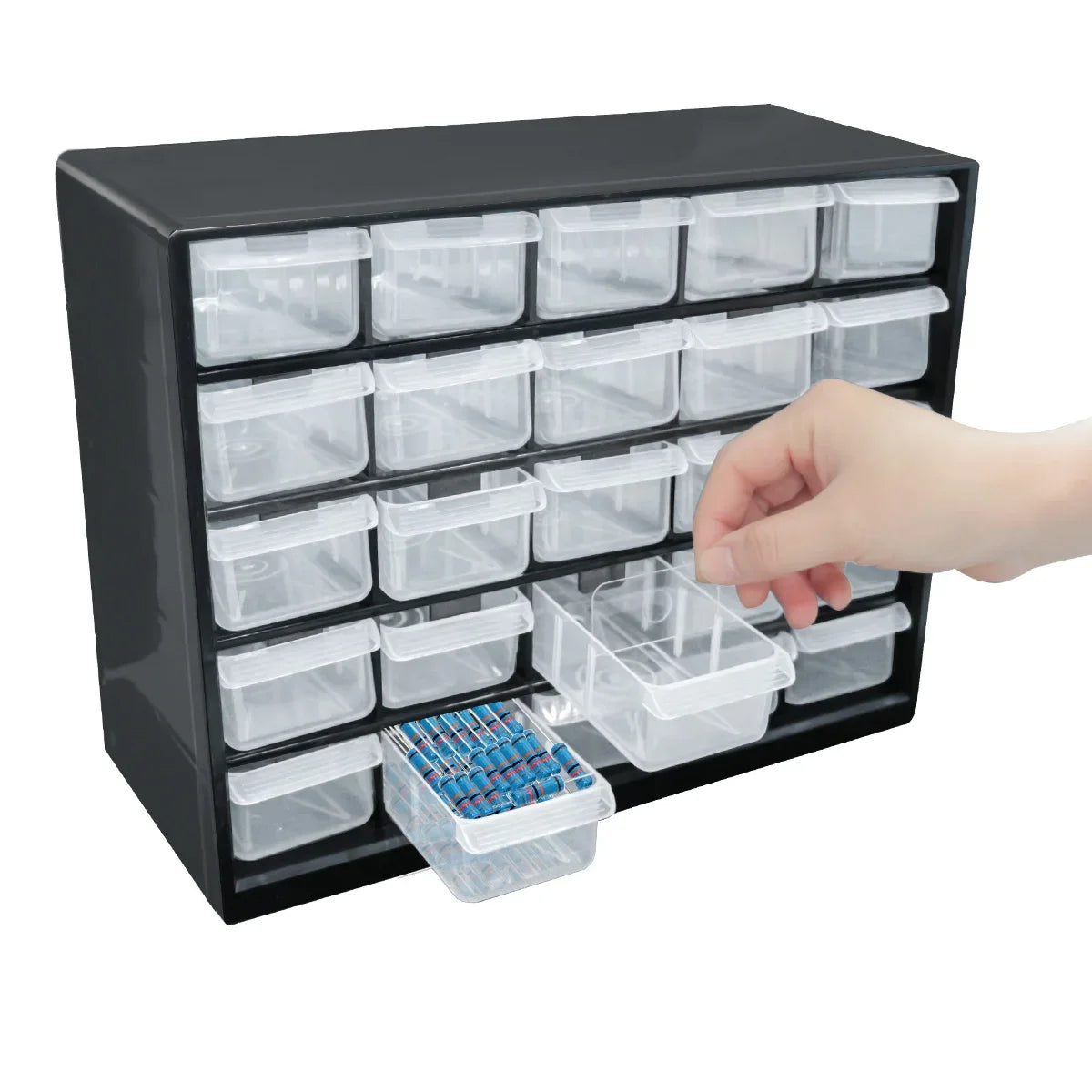 A hand is placing small blue parts into a clear plastic compartment of a black wall-mounted organizer with drawers.