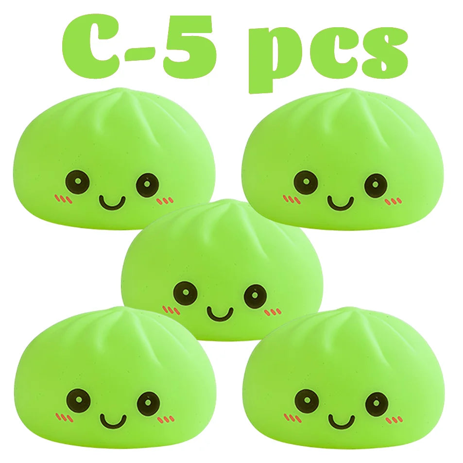Cinco juguetes de dumplings brillantes y suaves de color verde, vistos desde arriba