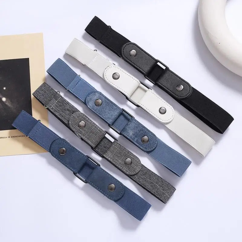 A collection of five stretch elastic belts in black, gray, and white leather with metal buckles displayed on a light backgrou