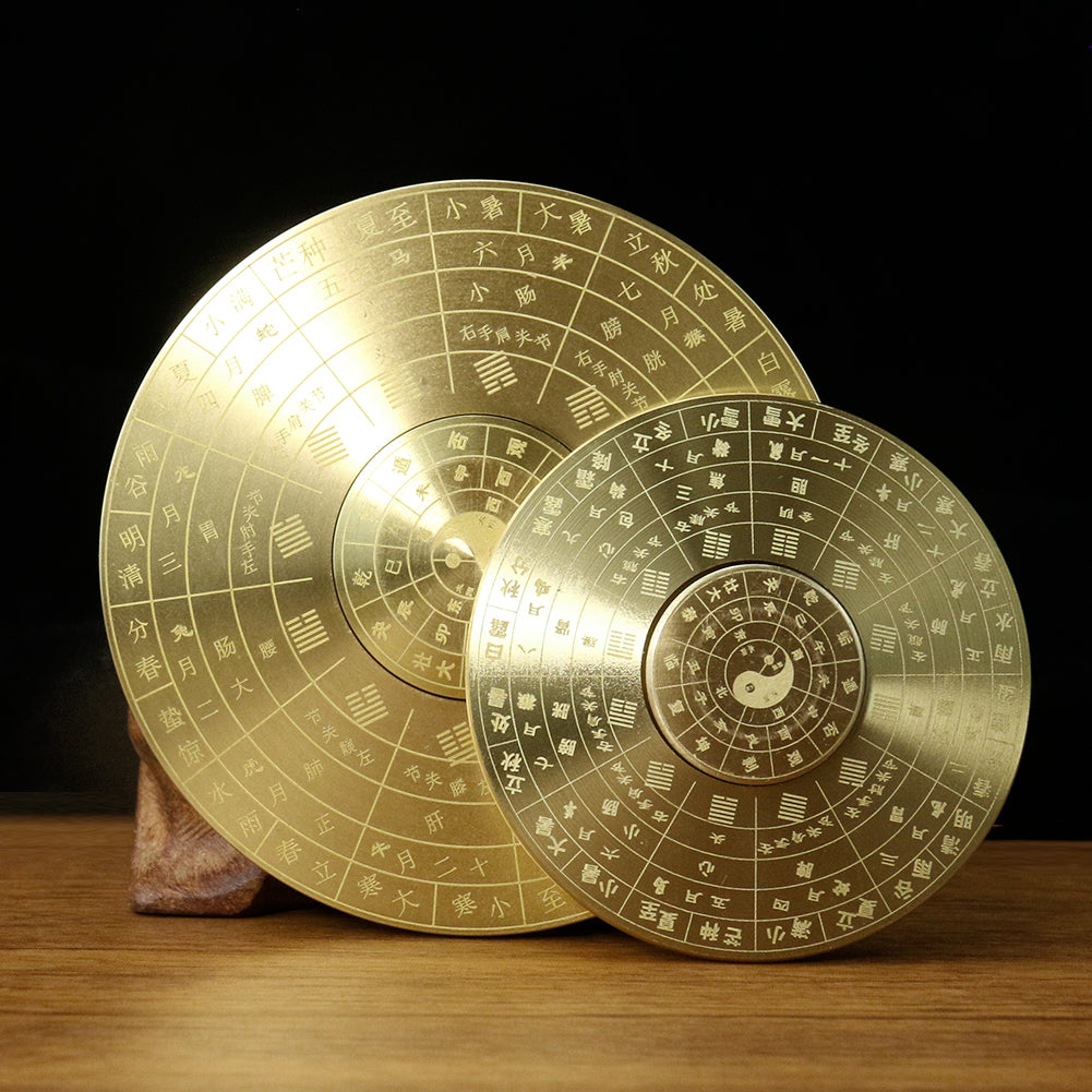 Solid brass Feng Shui compass with Yin Yang and eight trigrams laid on a wooden surface.