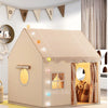 A beige play tent shaped like a house with a straw roof and decorative bunting for children.