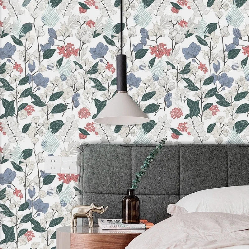 A close-up of a bedroom featuring a headboard and a pendant light, decorated with boho leaf peel-and-stick wallpaper.