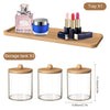 Acrylic bathroom storage set with bamboo lids showing a perfume bottle, jar, and three glass storage tanks.