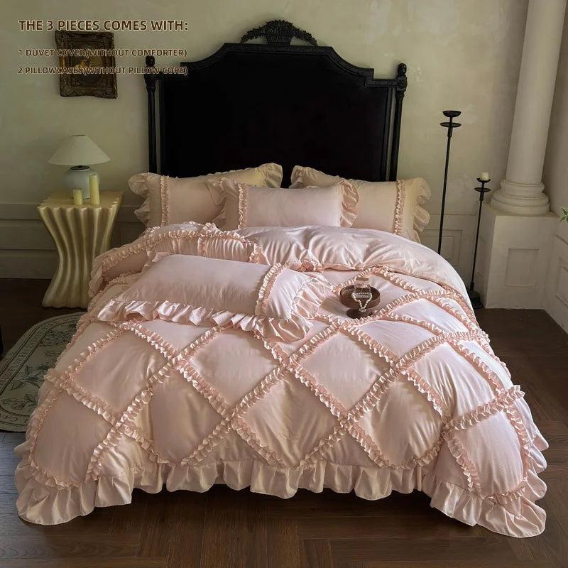 A pink ruffled duvet cover set with three pillowcases displayed on a bed against a dark headboard.