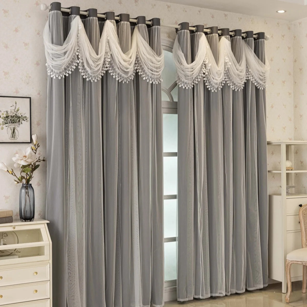 Gray sheer curtains with decorative lace trim hanging in a doorway
