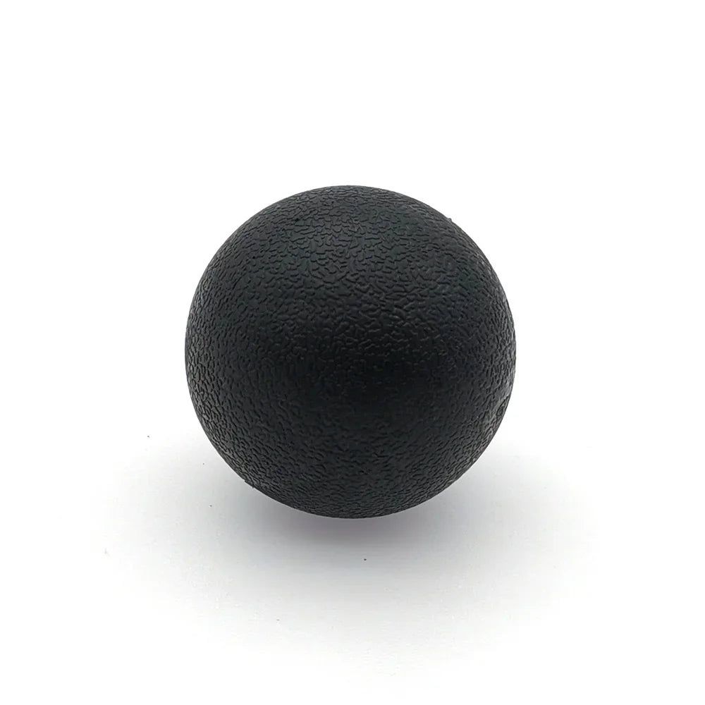 A black TPE peanut massage ball resting on a white surface.