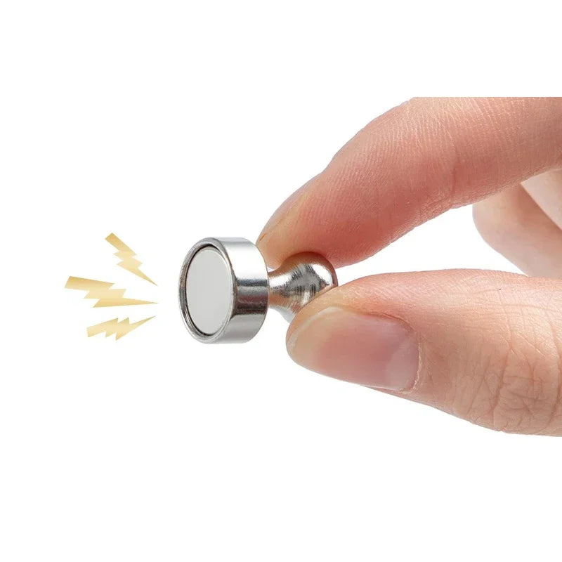 A hand is holding a silver neodymium magnetic pushpin, demonstrating its size and shape.