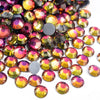 A close-up view of various colorful hotfix rhinestones in various shades of gold, pink, and green.