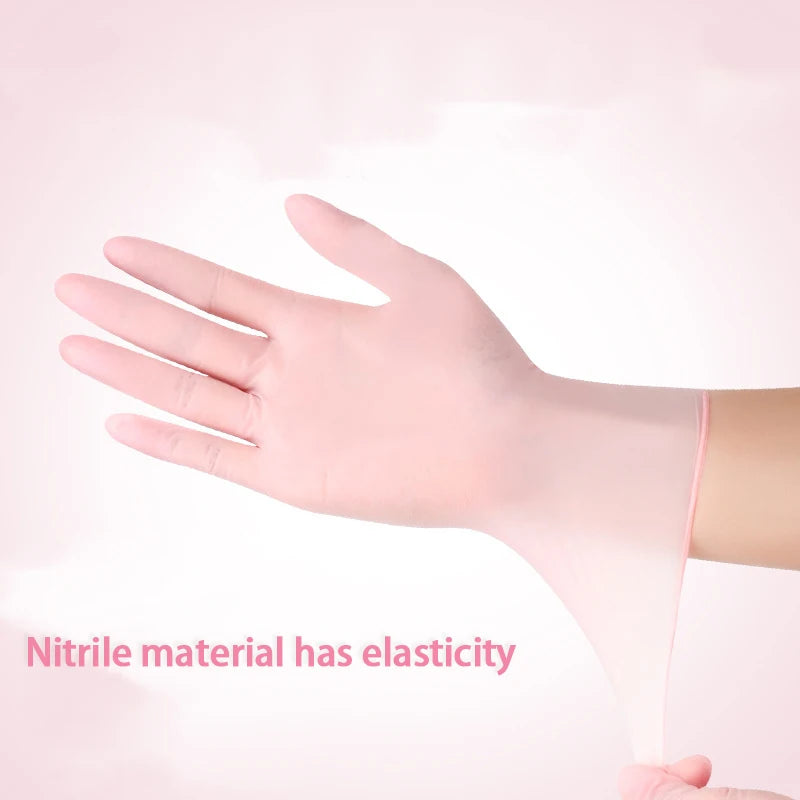 A hand wearing a pink disposable nitrile glove demonstrates the elasticity of the material.