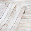 A piece of white distressed wood paneling or plank flooring with visible grain and texture.