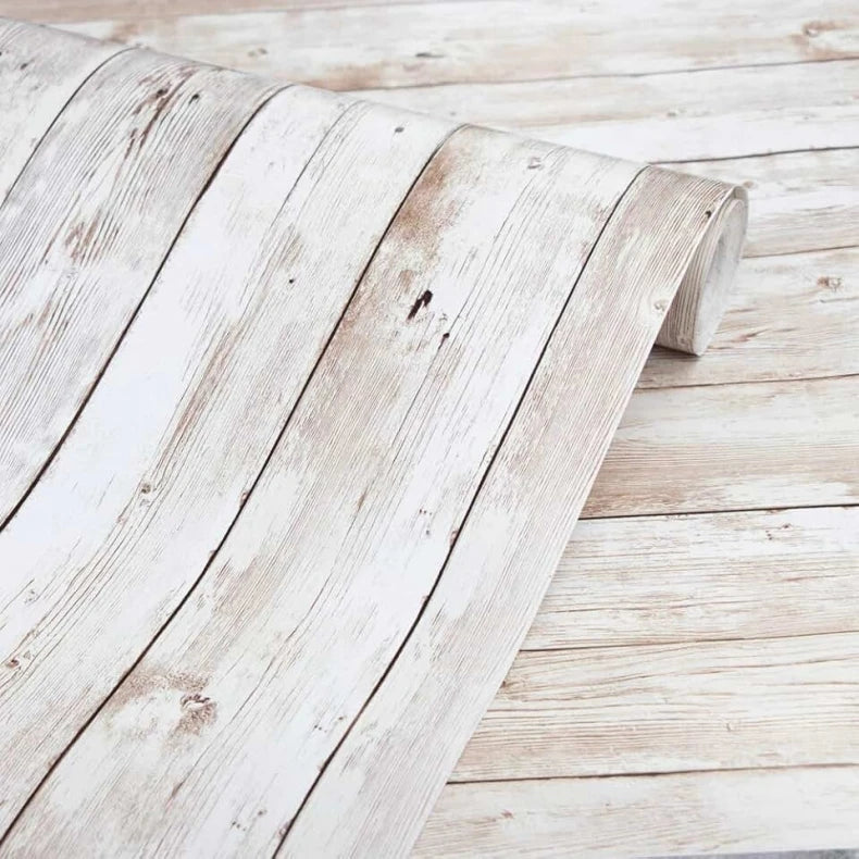 A piece of white distressed wood paneling or plank flooring with visible grain and texture.