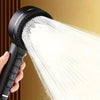 A hand is holding a black high-pressure handheld shower head, spraying a strong stream of water.