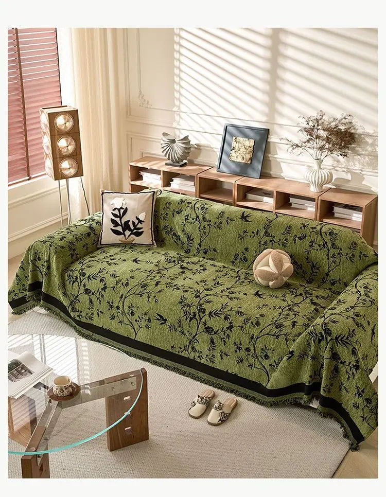 Moosgrüner Chenille-Sofas-Slipcover auf einem hellen Teppich in einem hellen Raum mit natürlichem Licht und Holzregalen.